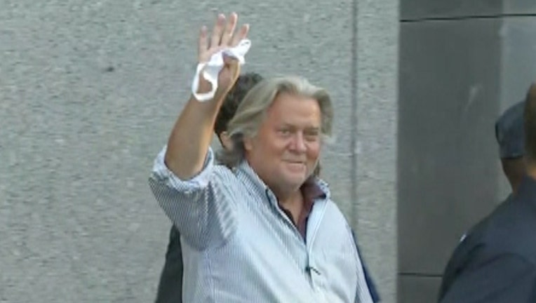 Steve Bannon smiles and waves