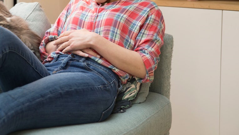 GettyImages-woman couch period abdominal pain