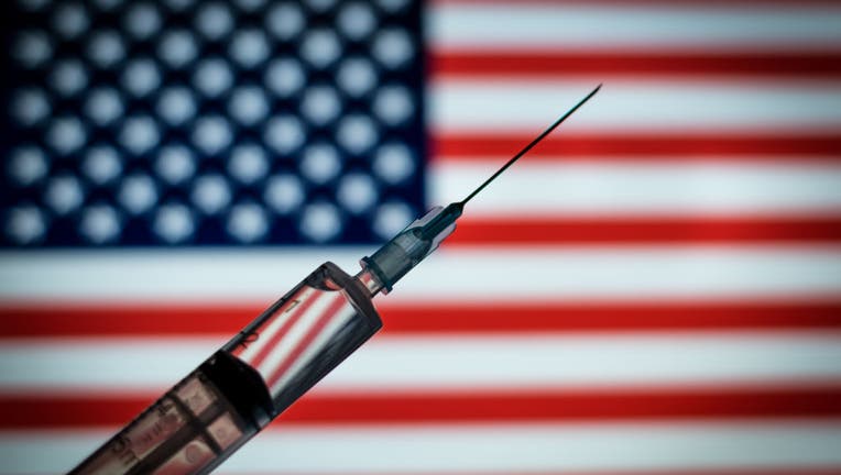 FILE - Photo illustration of the medical syringe is seen with the Usa flag in the background on August 18, 2020 in Rome, Italy.