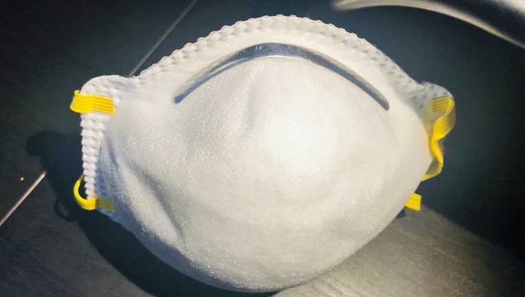White N95 respirator mask with yellow straps