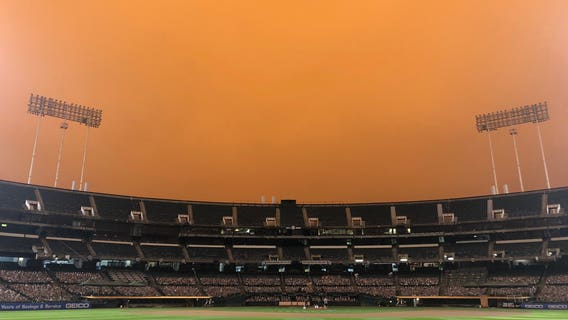 Smoke from wildfires creates eerie baseball scene in California