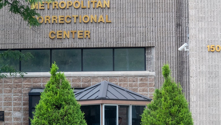 Front entrance of a federal jail with two trees in foreground and the words Metropolitan Correctional Center on the exterior