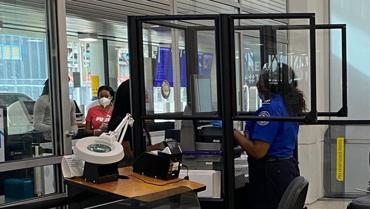 Clear barriers protect a TSA officer