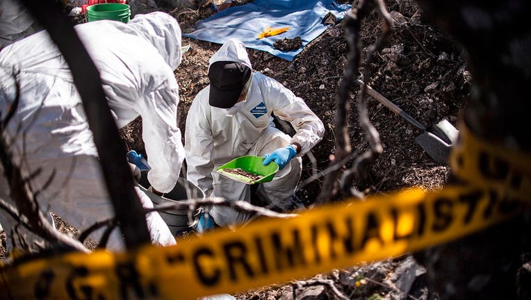 Forensic personnel work in the exhumation of human remains found in Huitzuco de los Figueroa, Guerrero state, Mexico.