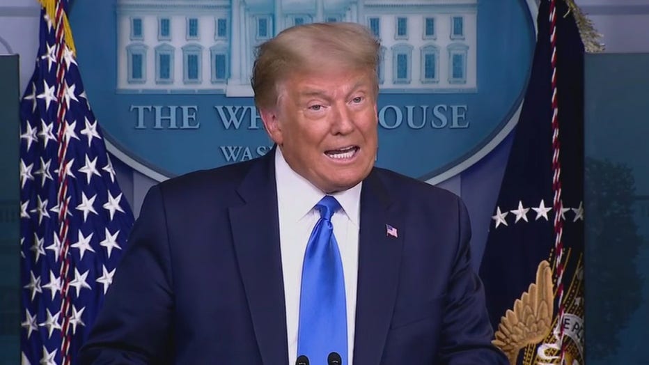 Trump, wearing blue suit and tie, speaks at a lectern in the White House