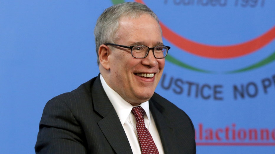 Smiling Scott Stringer wearing glasses, tie, and jacket
