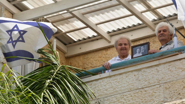 MODIIN, April 21, 2020 -- Holocaust survivors Dmitry Kazavchinski R, 85, and his wife Svetlana, 80, display a picture at their own house amid the COVID-19 pandemic in the central Israeli city of Modiin on April 21, 2020.