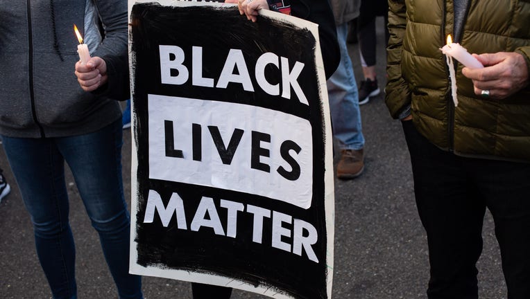 A person holds a Black Lives Matter sign (Photo by David Ryder/Getty Images)