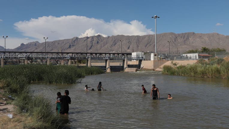 Young people, play in the water of the Rio Grande.