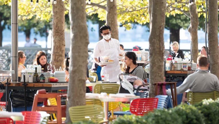 A waiter wears a face mask while serving food in New York City.