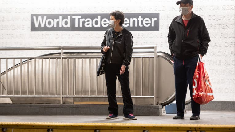 FILE People wear protective face masks at the subway platform in the World Trade Center transportation hub.