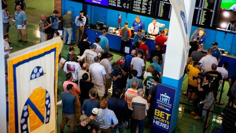 People line up to place bets at the Monmouth Park Sports Book.
