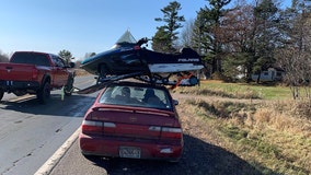 Trooper stops driver hauling snowmobile atop car