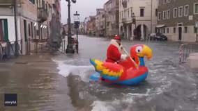 Santa paddles down flooded Venice street