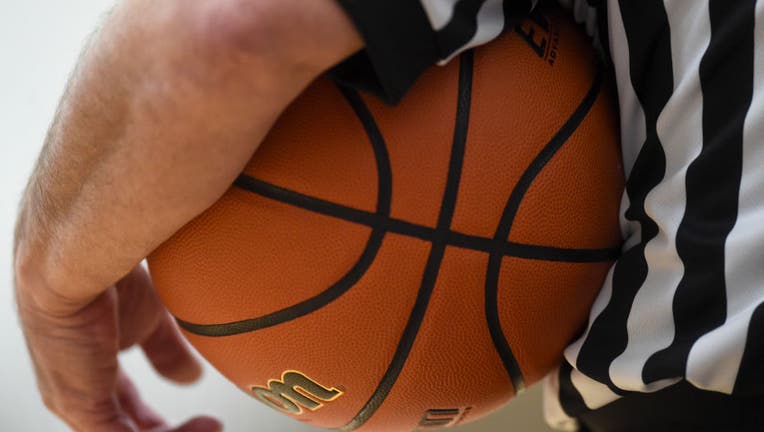 FILE- Referee holds basketball.