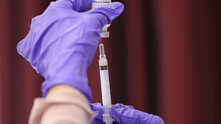 Nurses draw vaccine doses from a vial. (Photo by Win McNamee/Getty Images)
