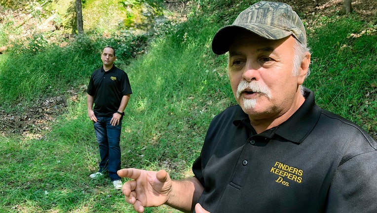 This Sept. 20, 2018 file photo, Dennis Parada, right, and his son Kem Parada stand at the site of the FBI's dig for Civil War-era gold in Dents Run, Pennsylvania. Government emails released under court order show that FBI agents were looking for gold when they excavated Dent's Run in 2018, though the FBI says that nothing was found. (AP Photo/Michael Rubinkam, File)