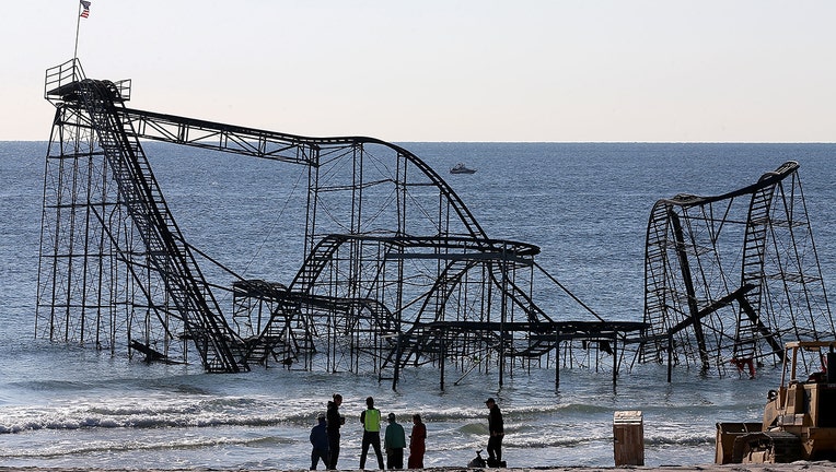 Workers prepare to remove the Star Jet roller coaster that has been in the ocean for six months after the Casino Pier is sat on collapsed when Superstorm Sandy hit, May 14, 2013 in Seaside Heights, New Jersey. The Casino Pier has contracted Weeks Marine to remove the Jet Star roller coaster from the Atlantic Ocean. (Photo by Mark Wilson/Getty Images)