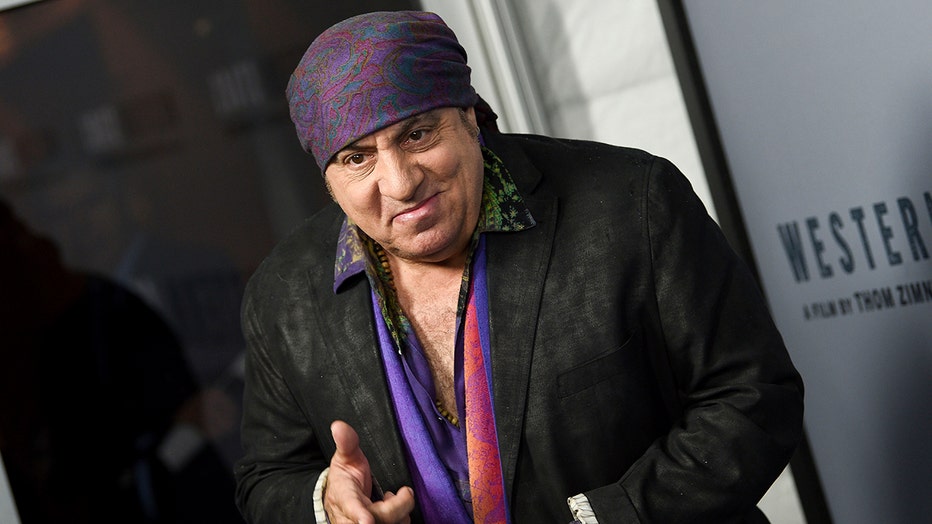 Actor and musician Steven Van Zandt wearing a black sports coat and colorful shirt and head covering