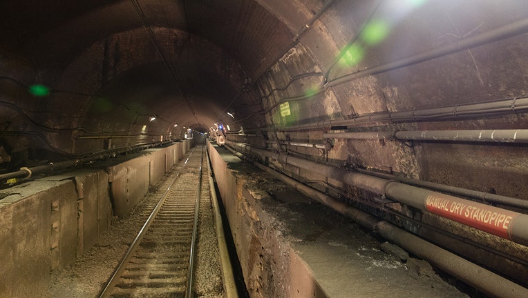 Interior view of a railroad tunnel under the Hudson River showing damage to concrete