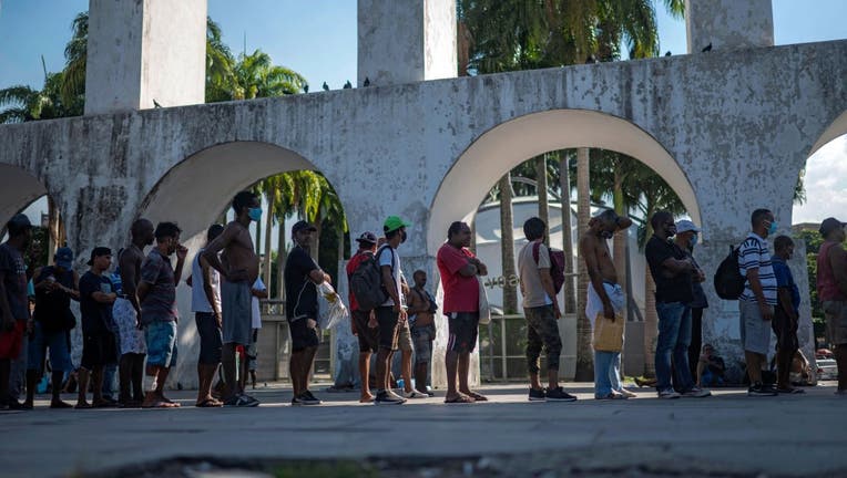 Homeless men queue to receive a meal.