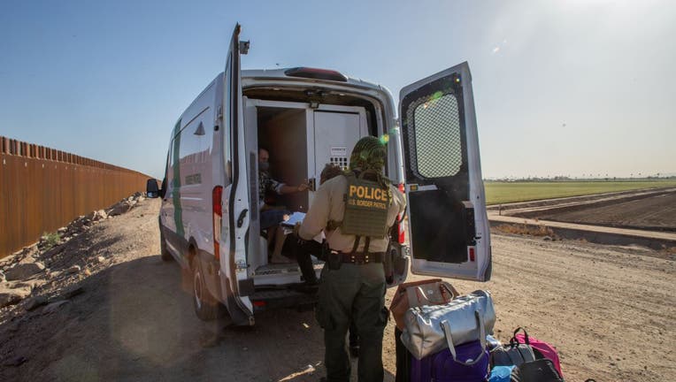 A family of asylum seekers from Colombia boards the Border Patrol Inmate transport