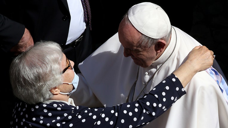 Pope Francis hugs Lidia Maksymowicz, a Polish survivor to Auschwitz, as he leaves the Courtyard of St Damasus at the end of his weekly General Audience on May 26, 2021 in Vatican City. (Photo by Franco Origlia/Getty Images)