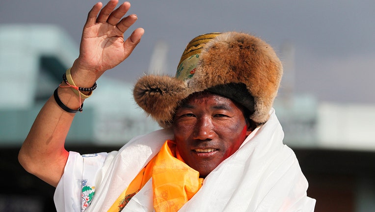 In this May 20, 2018, file photo, Nepalese veteran Sherpa guide, Kami Rita waves as he arrives in Kathmandu, Nepal. Rita, 51, an ace Sherpa guide scaled Mount Everest Friday for the 25th time breaking his own record for the most successful ascents of the world’s highest peak. (AP Photo/Niranjan Shrestha, File)