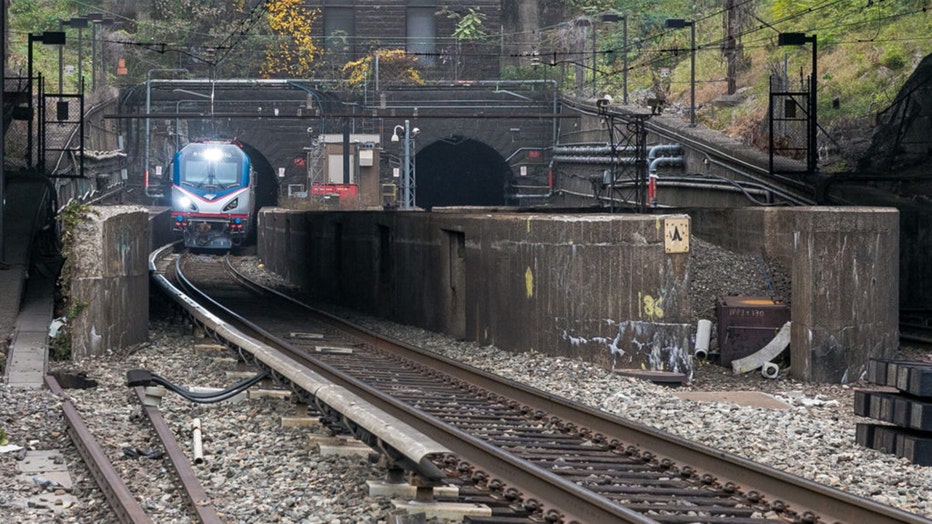 An Amtrak train emerges from a tunnel