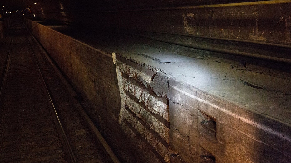 Interior view of a railroad tunnel under the Hudson River showing damage to concrete