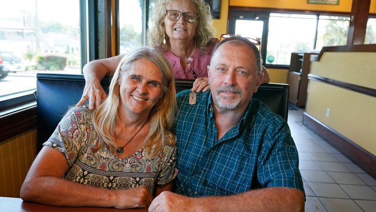 Two days after Debby-Neal Strickland, front left, and Jim Strickland were married in November, Debby donated a kidney to James' ex-wife Mylaen Merthe, center back, as the three get together Tuesday, May 25, 2021, at a restaurant in Ocala, Fla.