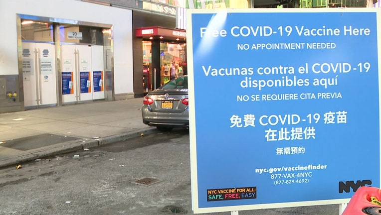 A blue and white sign outside a vaccination site 