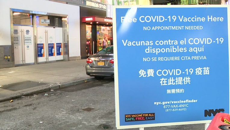 A blue and white sign outside a vaccination site