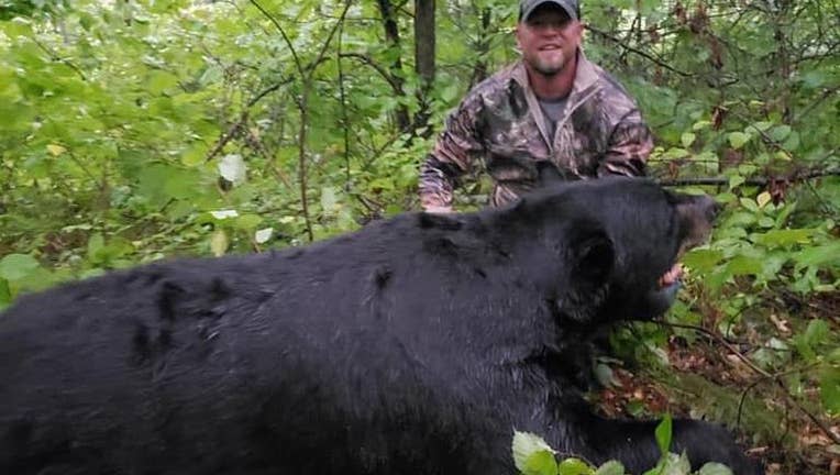 Brett Stimac poses with a bear he shot in September 2019 . (Facebook / Cuyuna Lakes Community Watch)