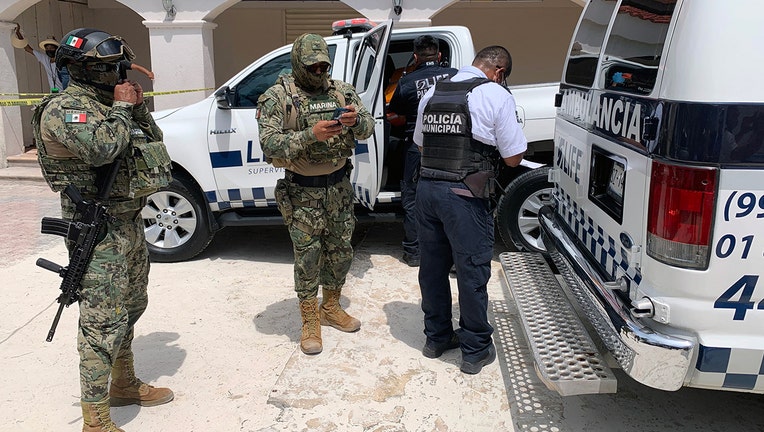 Members of the Mexican Navy are seen outiside of an ambulance carrying a tourist injured during a shooting in the tourist area of Playa Tortugas in Cancun, Mexico on June 11, 2021. -(Photo by ELIZABETH RUIZ/AE/AFP via Getty Images)