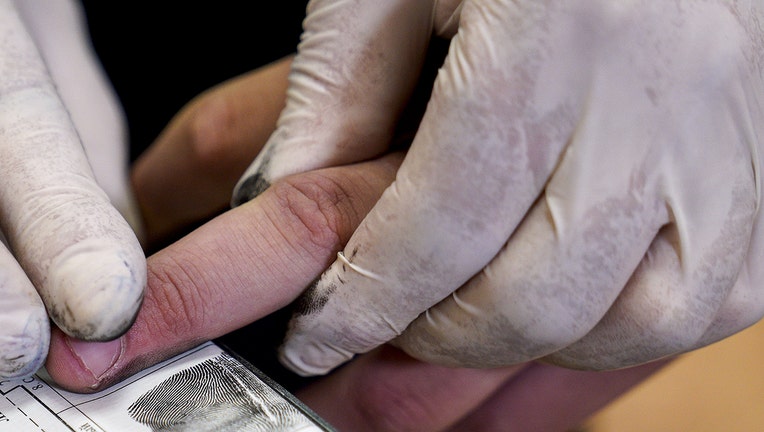 A file photograph shows a person being fingerprinted. (Photo by Vitaly Nevar\TASS via Getty Images)