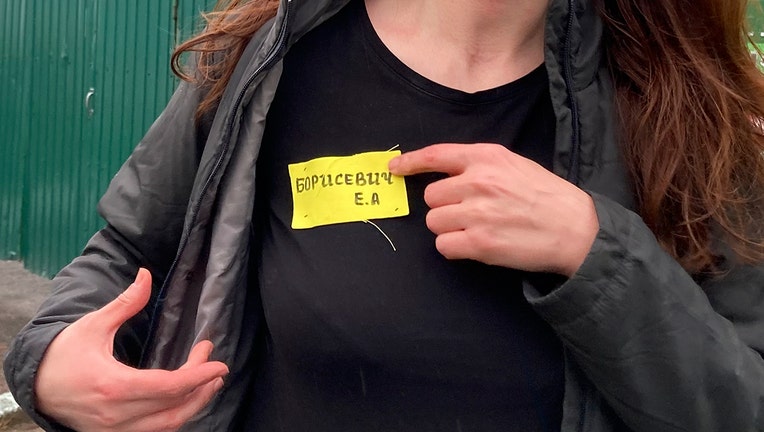 In this May 19, 2021 file photo, Belarusian journalist Katsiaryna Barysevich, who was sentenced to six months over her investigation into a protester's death, shows her yellow prison's label. (AP Photo)