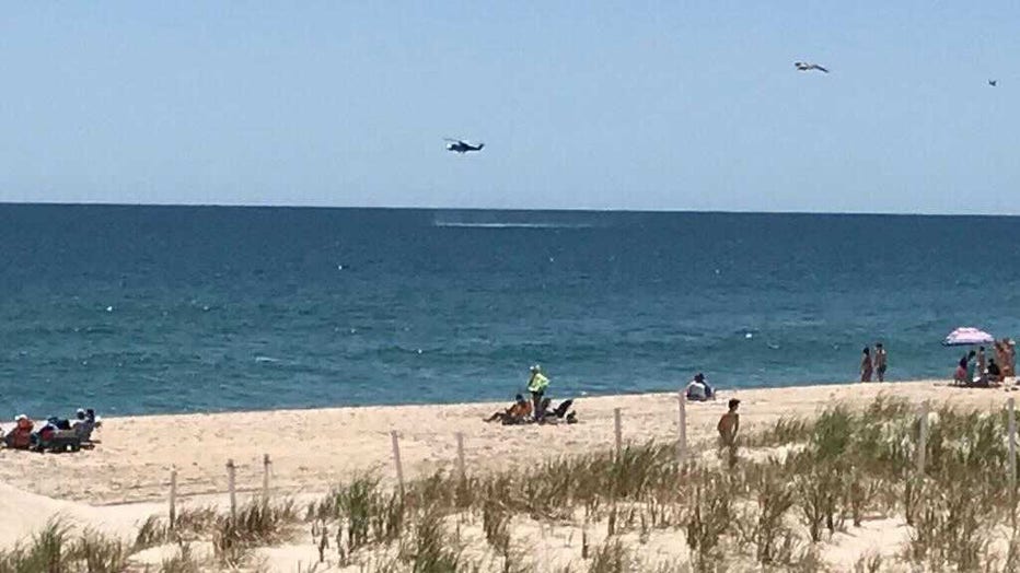 A helicopter searches the waters off 18th Street in Beach Haven, NJ after an aircraft reportedly went down further north off 26th Street in Spray Beach.