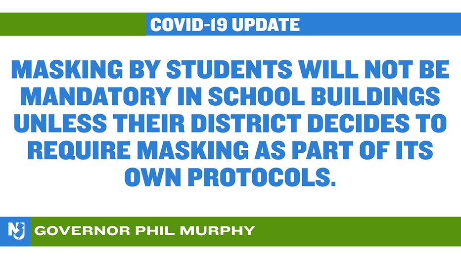 A slide that reads 'COVID-19 UPDATE; MASKING BY STUDENTS WILL NOT BE MANDATORY IN SCHOOL BUILDINGS UNLESS THEIR DISTRICT DECIDES TO REQUIRE MASKING AS PART OF ITS OWN PROTOCOLS' GOVERNOR PHIL MURPHY