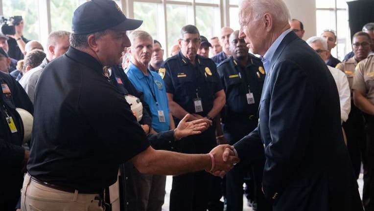 President Joe Biden(R) shakes hands with Jimmy Patronis, Florida's Chief Financial Officer, as he meets with first responders to the collapse of the 12-story Champlain Towers South condo building in Surfside, during a meeting with them in Miami Beach, Florida, July 1, 2021. (Photo by SAUL LOEB/AFP via Getty Images)