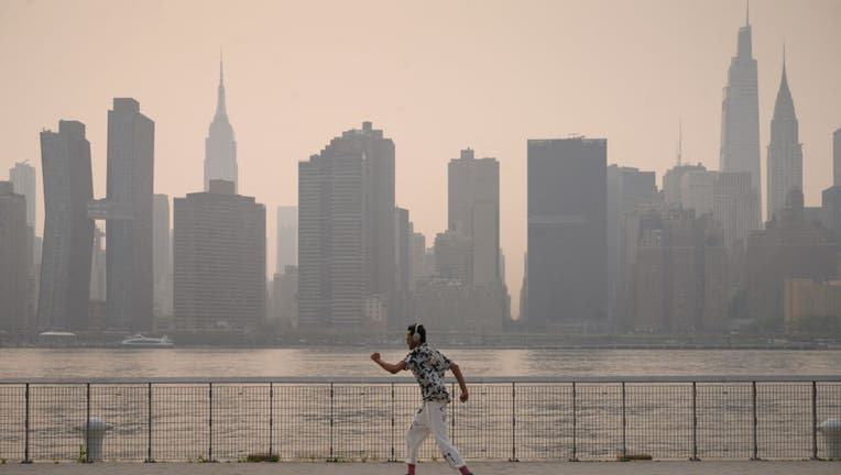 A man skates before the Manhattan city skyline at a park in the Brooklyn borough of New York on July 20, 2021. (Photo by ED JONES/AFP via Getty Images)