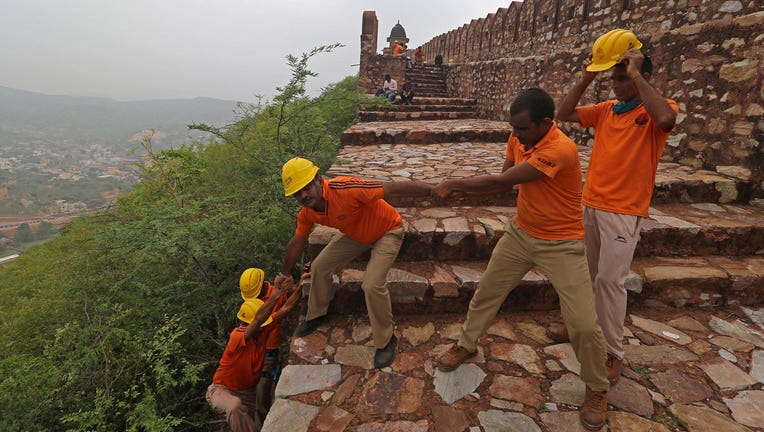 Members of State Disaster Response Force conduct a search operation near the watchtowers of the Amer Fort on the outskirts of Jaipur on July 12, 2021, after at least 11 people were killed in lightning strikes at the fort. (Photo by AFP via Getty Images)
