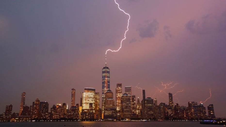 Lightning strikes One World Trade Center during a thunderstorm over lower Manhattan as the sun sets in New York City on July 6, 2021 as seen from Jersey City, New Jersey. (Photo by Gary Hershorn/Getty Images)