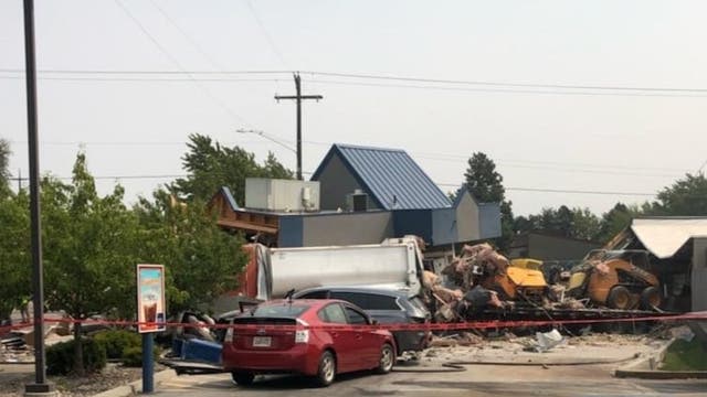 Driver charged after dump truck plows into cars, buildings