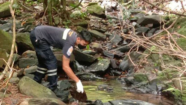An officer inspects the scene where a woman was found dead at a secluded spot on the southern island of Phuket, Thailand, on Thursday, Aug. 5, 2021. Thai media, quoting police, said the woman was a 57-year-old Swiss national. (AP Photo)