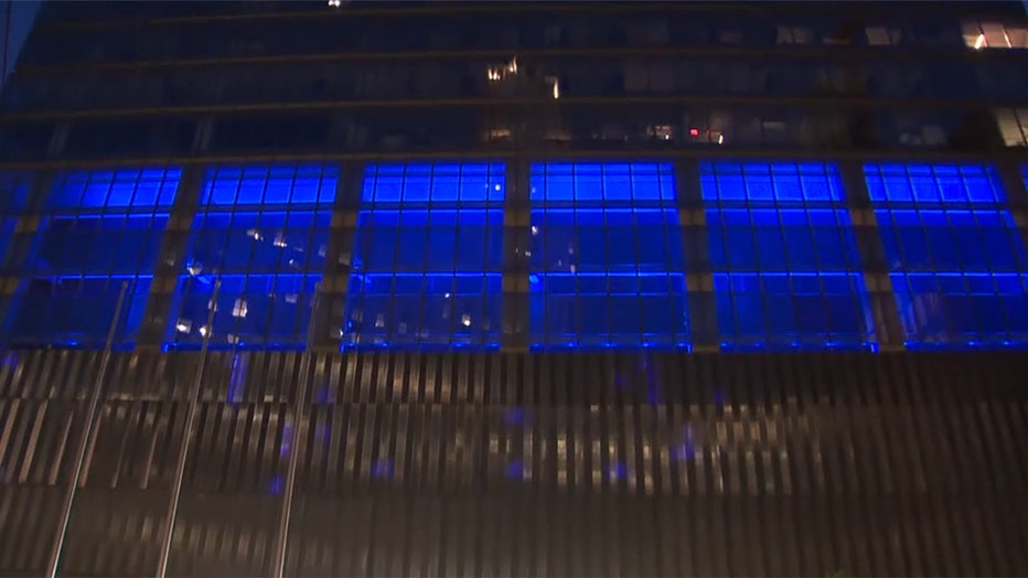 A view of a portion of the facade of a skyscraper with glowing blue lighting