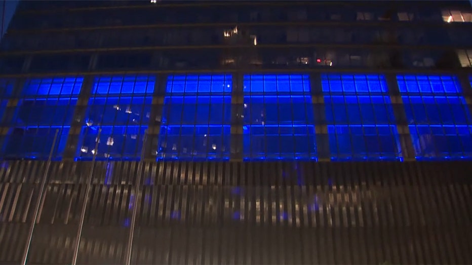 A view of a portion of the facade of a skyscraper with glowing blue lighting