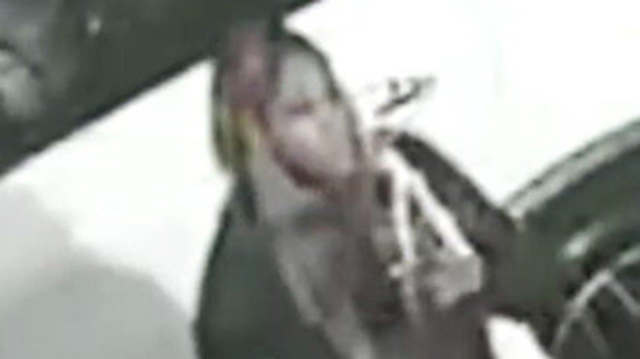 A blurry security camera image showing a person