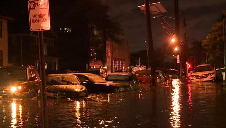Floodwaters surround parked cars on a city street