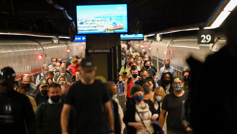 Commuters wearing masks disembark from a Metro-North train during the morning rush hour commute on May 25, 2021 in New York City.